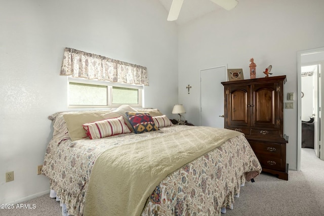 bedroom featuring light colored carpet, ceiling fan, and a high ceiling