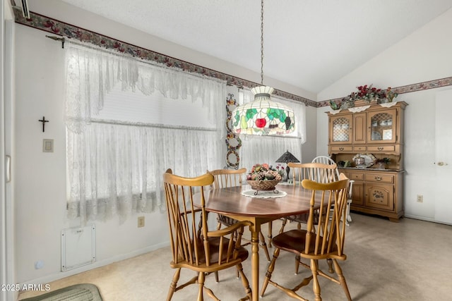 dining room featuring vaulted ceiling and baseboards