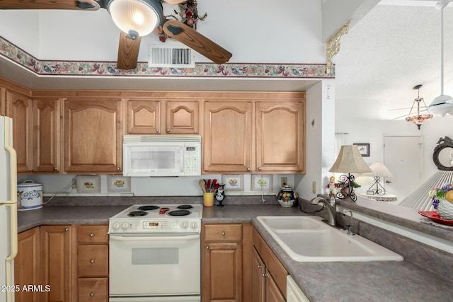 kitchen featuring dark countertops, white appliances, visible vents, and a sink