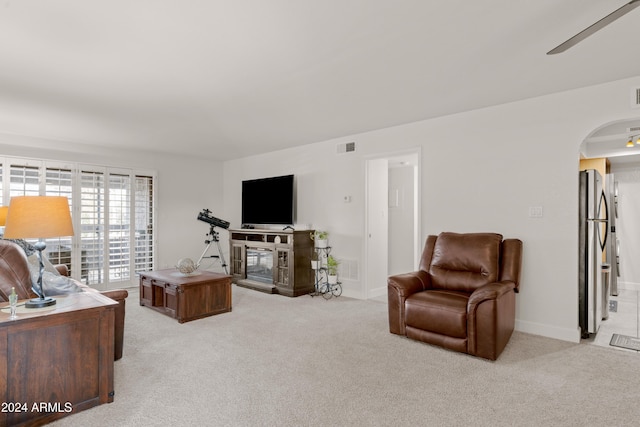 carpeted living room with ceiling fan