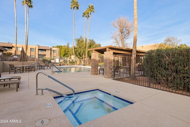 view of swimming pool featuring a patio area and a community hot tub