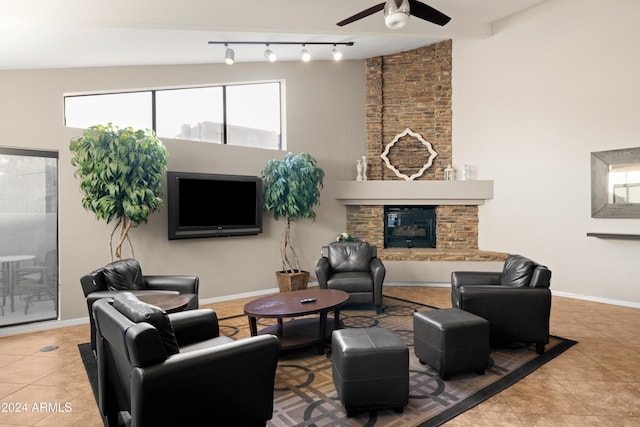 living room featuring a fireplace, light tile patterned floors, rail lighting, and ceiling fan