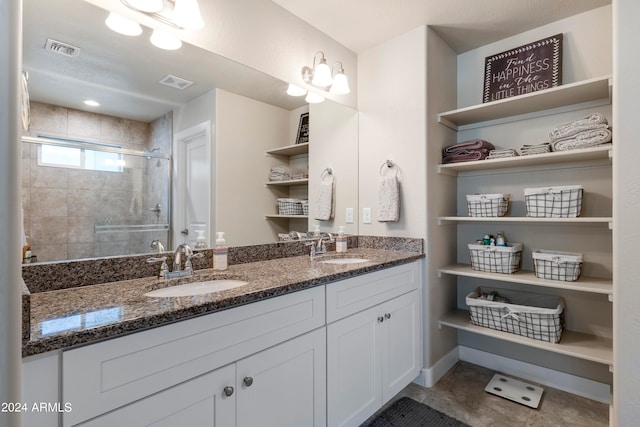 bathroom featuring tile patterned floors, vanity, and a shower with shower door