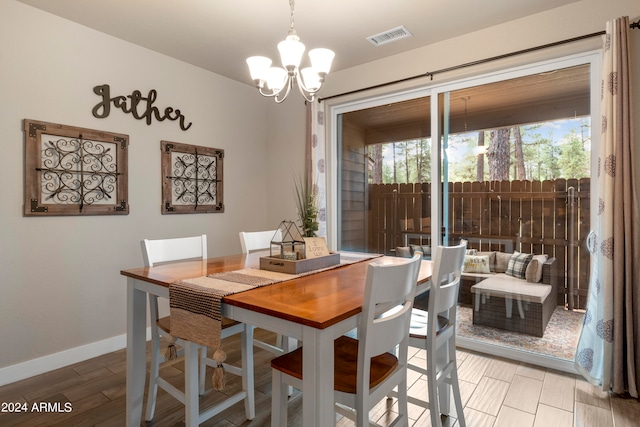 dining room featuring light wood-type flooring and a chandelier