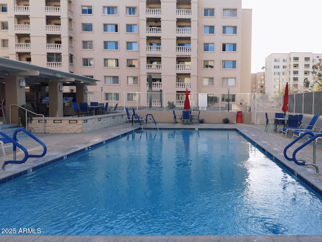 community pool featuring fence and a patio