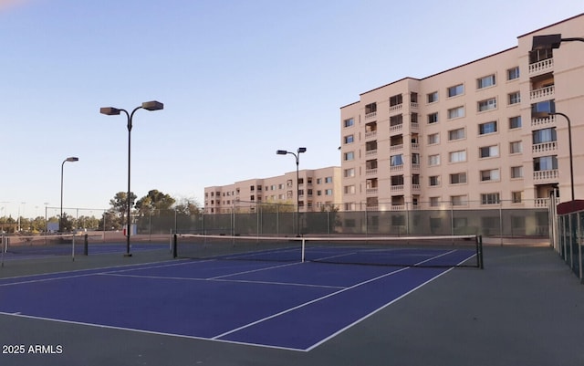 view of tennis court featuring fence