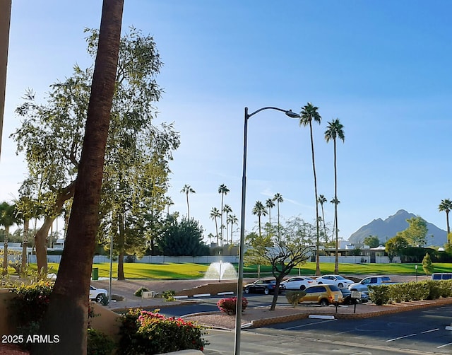 view of property's community with uncovered parking and a water and mountain view