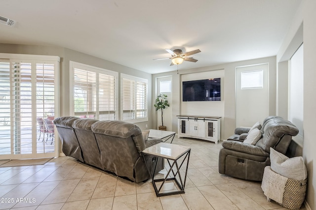 living area with visible vents, ceiling fan, and light tile patterned floors