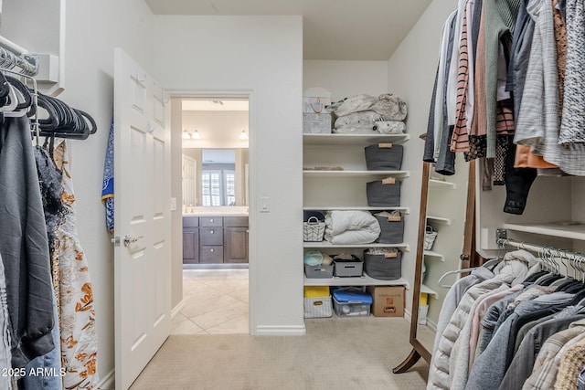 spacious closet featuring light colored carpet and light tile patterned flooring