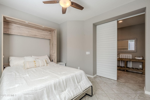 bedroom featuring ceiling fan, light tile patterned floors, and baseboards