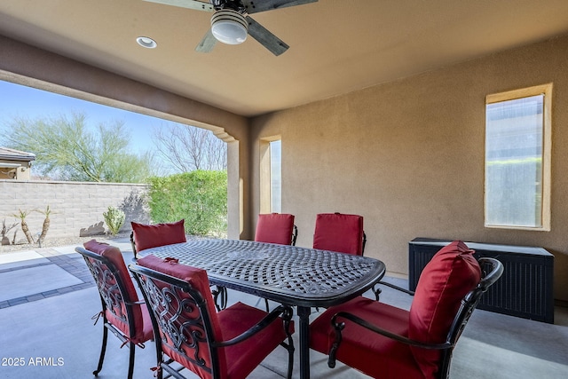 view of patio with ceiling fan, fence, and outdoor dining area