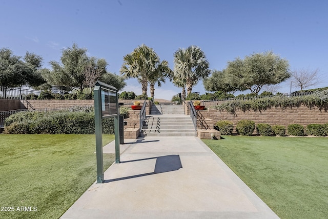 view of home's community with fence and a yard