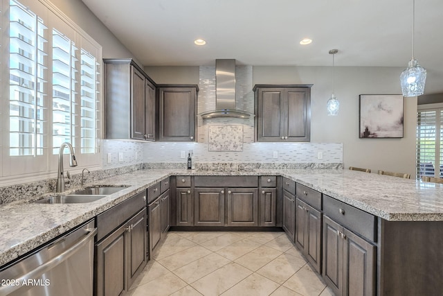 kitchen with decorative backsplash, stainless steel dishwasher, a sink, wall chimney range hood, and a peninsula