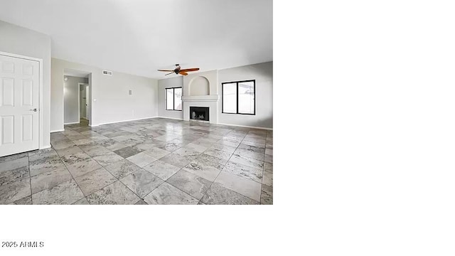 3761 W Kent Dr, Chandler, AZ 85226 - unfurnished living room featuring baseboards, ceiling fan, a large fireplace, and stone tile flooring
