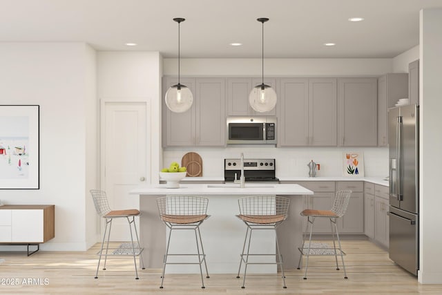 kitchen with gray cabinetry, decorative backsplash, and stainless steel appliances