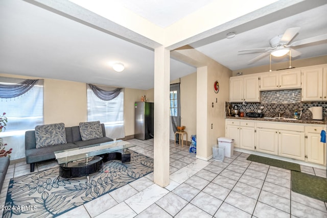 kitchen with backsplash, sink, ceiling fan, stainless steel fridge, and beam ceiling