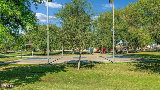 view of property's community featuring a playground, a yard, and basketball court