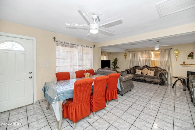 dining room featuring plenty of natural light, ceiling fan, light tile patterned floors, and a fireplace