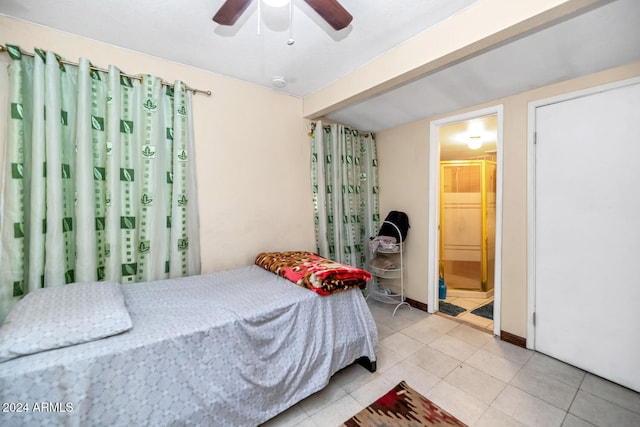 tiled bedroom featuring ceiling fan and ensuite bathroom