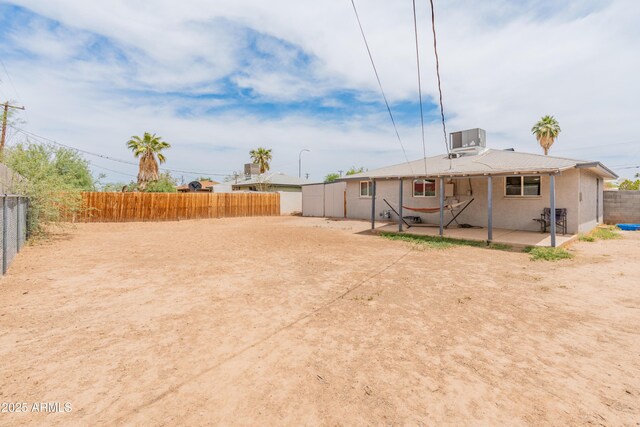 3806 N 64th Dr, Phoenix, AZ 85033 - back of property featuring a patio, central AC unit, and a fenced backyard