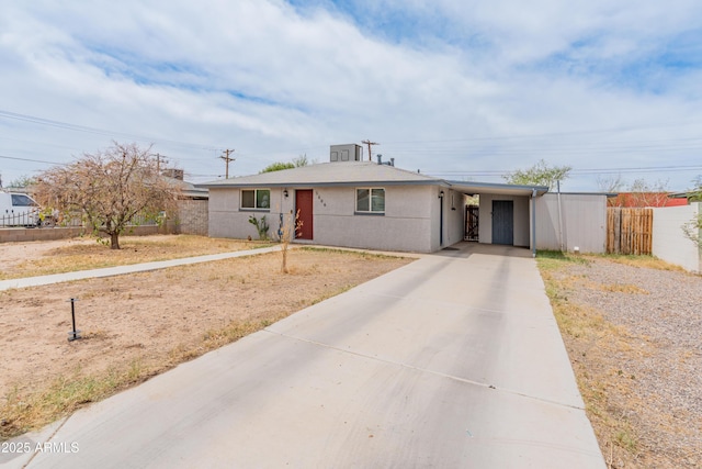 3806 N 64th Dr, Phoenix, AZ 85033 - view of front of property with concrete driveway, an attached carport, fence, and stucco siding