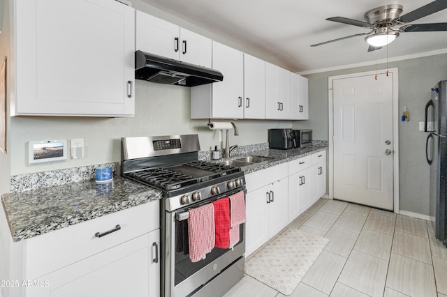 3806 N 64th Dr, Phoenix, AZ 85033 - kitchen with under cabinet range hood, stainless steel gas stove, a sink, a ceiling fan, and white cabinetry