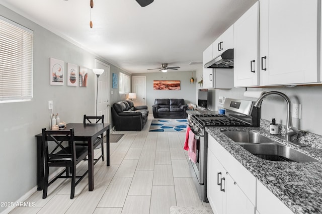 3806 N 64th Dr, Phoenix, AZ 85033 - kitchen with a ceiling fan, stainless steel gas range oven, a sink, under cabinet range hood, and white cabinets