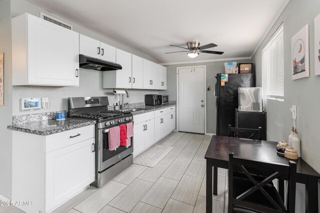 3806 N 64th Dr, Phoenix, AZ 85033 - kitchen with stainless steel appliances, under cabinet range hood, ceiling fan, and white cabinets