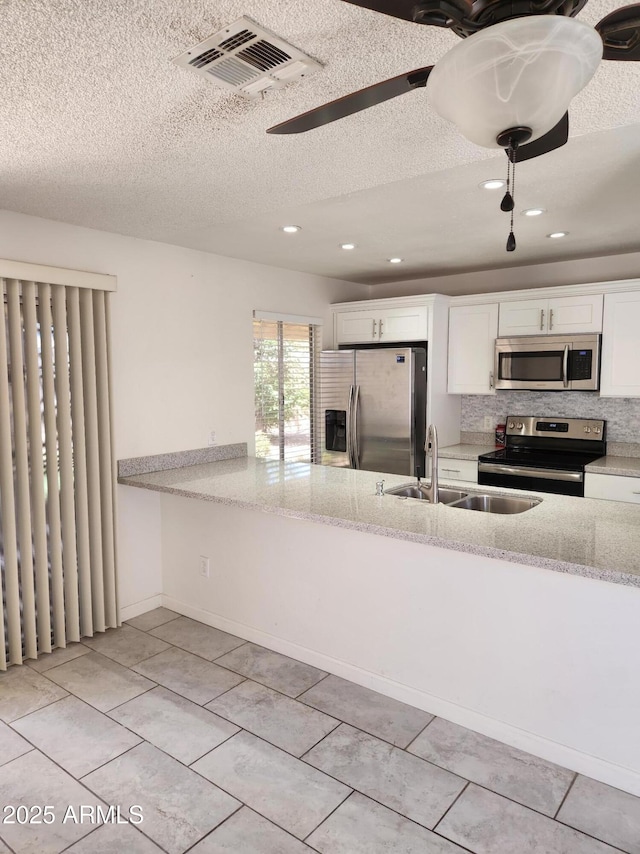 3329 W Ross Ave W, Phoenix, AZ 85027 - kitchen with stainless steel appliances, a textured ceiling, white cabinetry, light tile patterned flooring, and light stone countertops