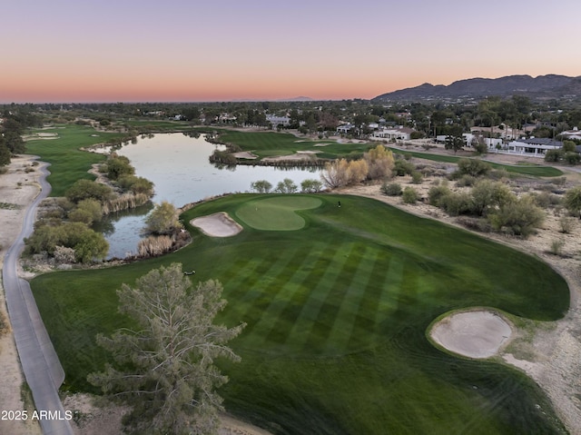 aerial view at dusk featuring a water and mountain view