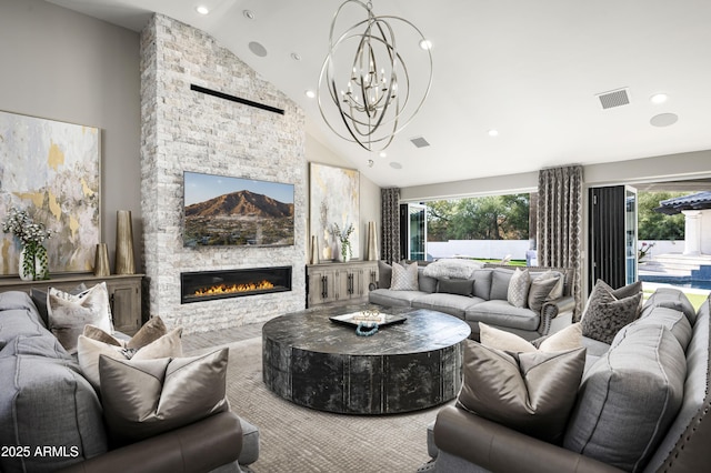 living room with high vaulted ceiling, a fireplace, a wealth of natural light, and a chandelier