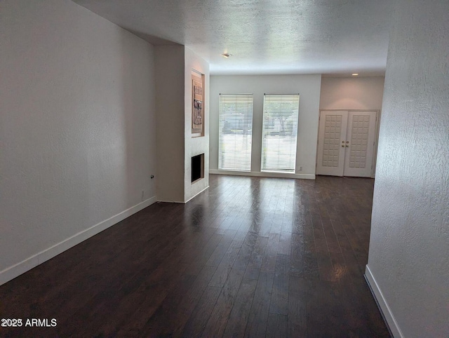 unfurnished room with dark hardwood / wood-style floors and a textured ceiling