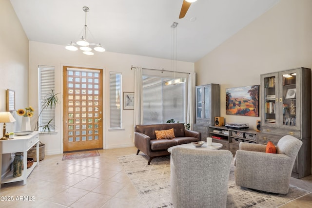 living room with light tile patterned floors, ceiling fan, a chandelier, high vaulted ceiling, and baseboards