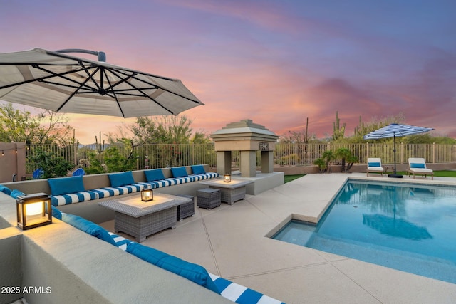 pool at dusk featuring an outdoor living space, a patio, and a fenced backyard