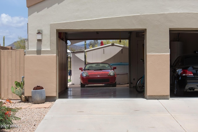 garage featuring driveway and water heater