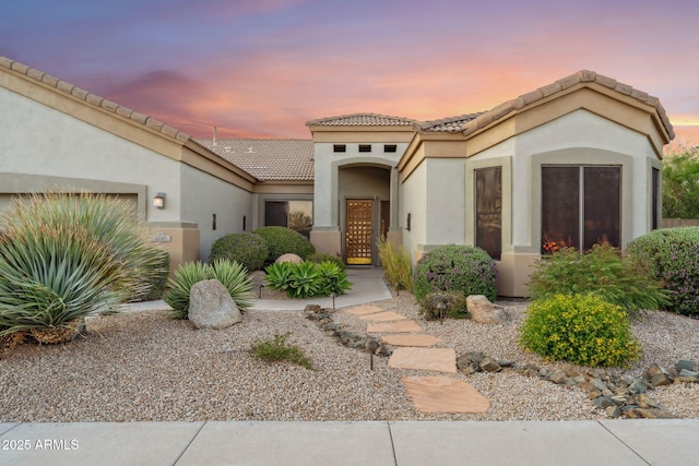 view of front of property with stucco siding and a tile roof
