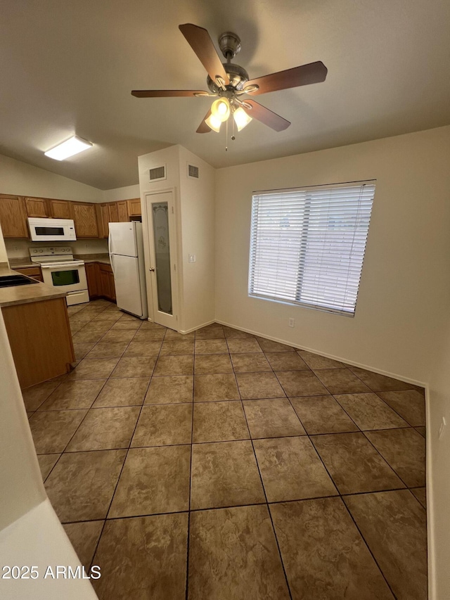 13004 W Saint Moritz Ln, El Mirage, AZ 85335 - kitchen with white appliances, brown cabinets, a ceiling fan, tile patterned flooring, and vaulted ceiling