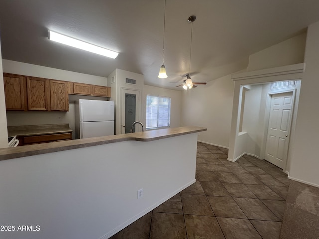 13004 W Saint Moritz Ln, El Mirage, AZ 85335 - kitchen featuring freestanding refrigerator, ceiling fan, hanging light fixtures, brown cabinets, and dark tile patterned floors