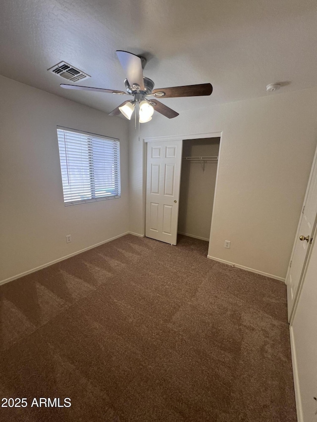 13004 W Saint Moritz Ln, El Mirage, AZ 85335 - unfurnished bedroom featuring dark carpet, a closet, and ceiling fan