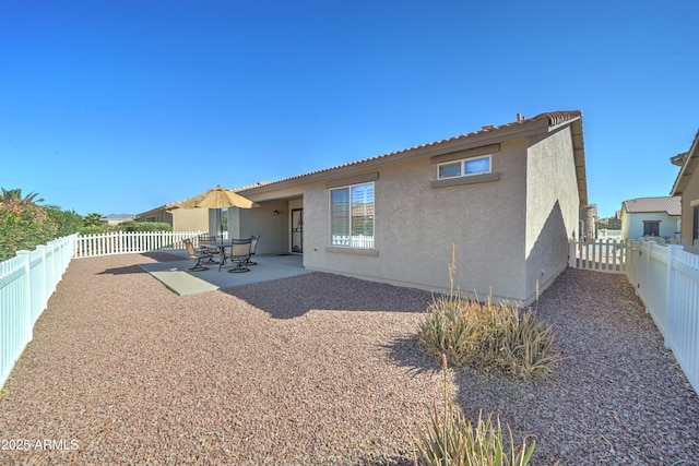 back of house featuring a patio area, a fenced backyard, and stucco siding