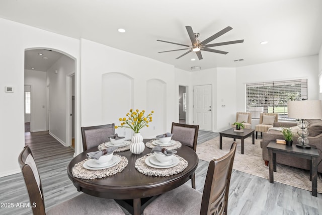 4140 E Claxton Ave, Gilbert, AZ 85297 - dining area featuring light wood finished floors, ceiling fan, arched walkways, recessed lighting, and baseboards