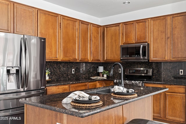 4140 E Claxton Ave, Gilbert, AZ 85297 - kitchen featuring appliances with stainless steel finishes, dark stone countertops, a sink, and brown cabinetry