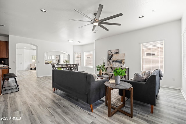 4140 E Claxton Ave, Gilbert, AZ 85297 - living room featuring arched walkways, ceiling fan, light wood finished floors, baseboards, and recessed lighting