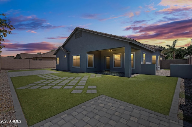 4140 E Claxton Ave, Gilbert, AZ 85297 - back of house at dusk featuring a patio, stucco siding, and a tiled roof