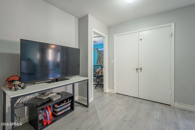 foyer entrance featuring a textured ceiling and light wood-type flooring