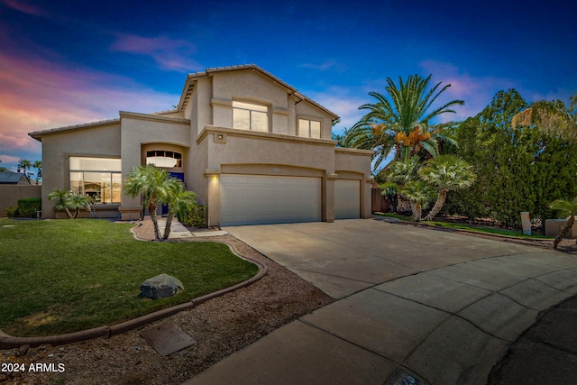 view of front of home featuring a garage and a yard