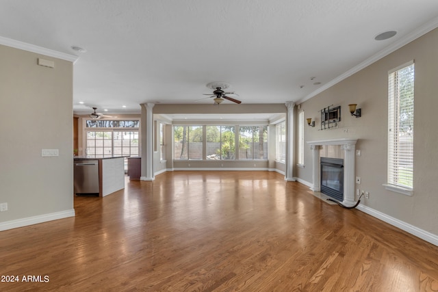 unfurnished living room with hardwood / wood-style floors, crown molding, ceiling fan, and ornate columns