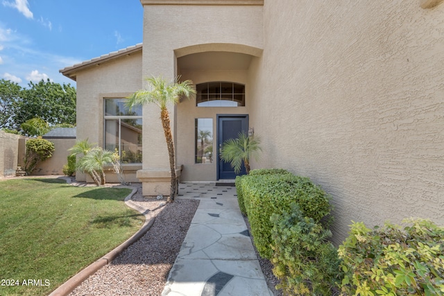 entrance to property with a lawn