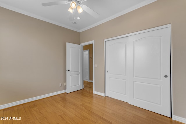 unfurnished bedroom with ornamental molding, ceiling fan, light hardwood / wood-style floors, and a closet