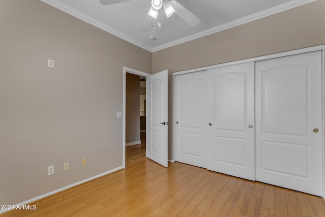 unfurnished bedroom with crown molding, ceiling fan, light wood-type flooring, and a closet